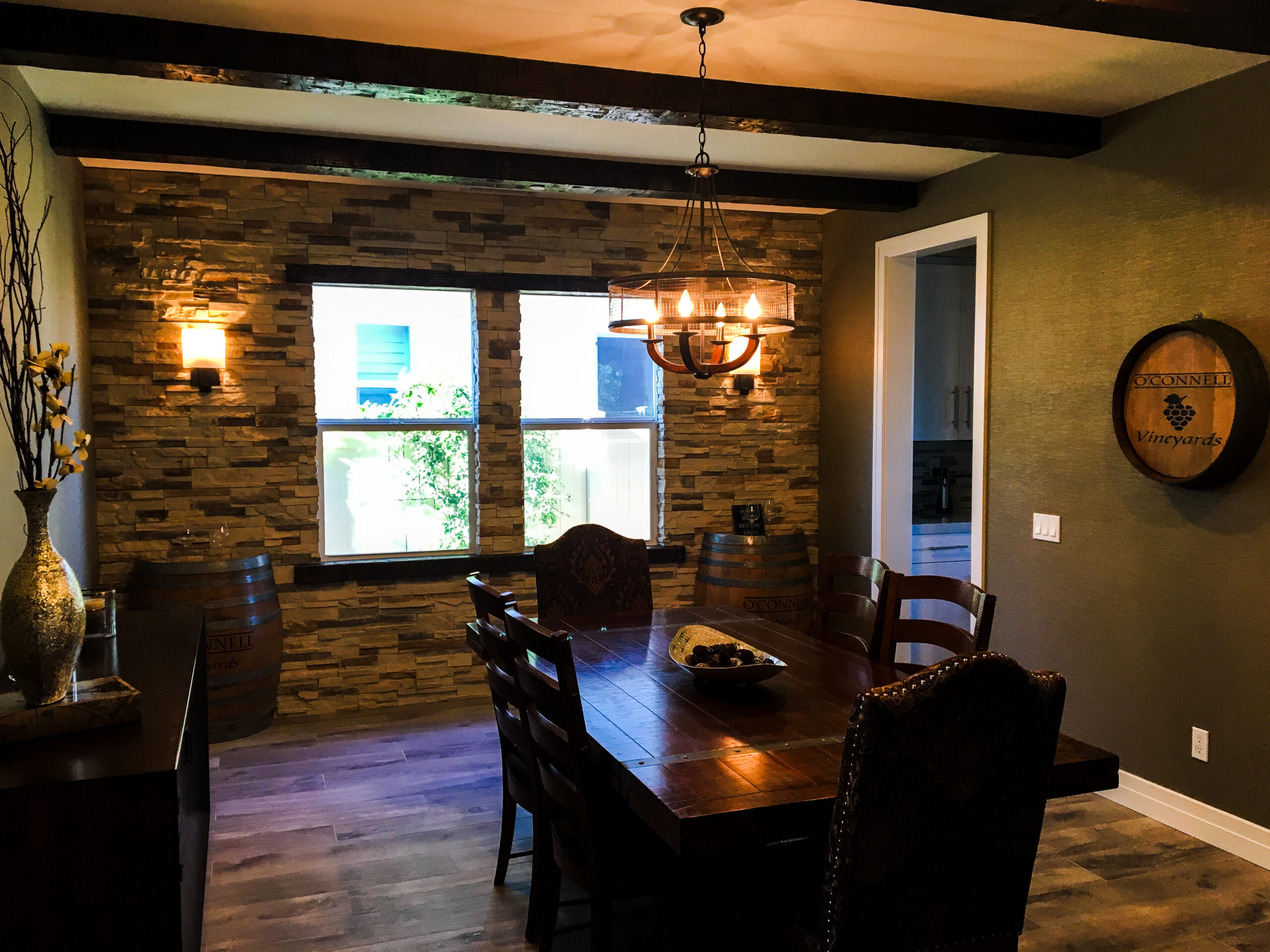 Residential family room with stone walls and a custom installed chandelier. 