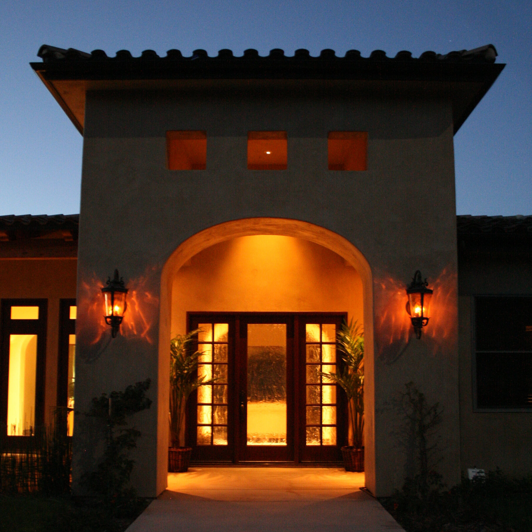 Customer residential home with warm exterior lighting framing the entry way. 